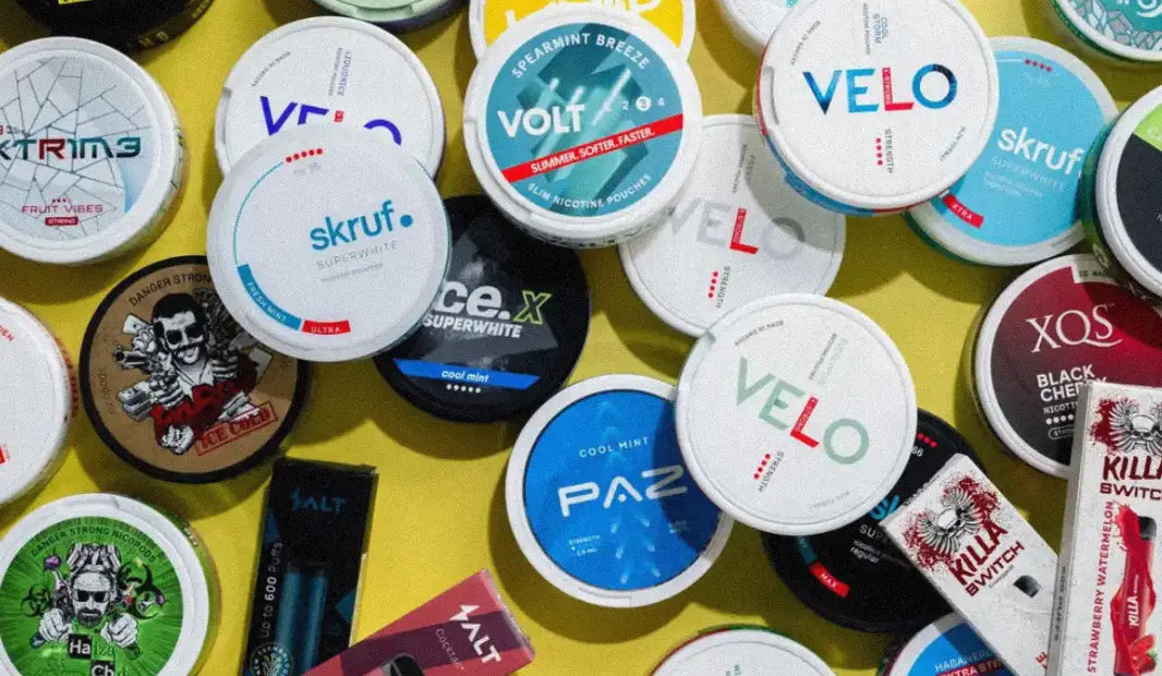 حاويات تبغ دائرية بيضاء وخضراء تحمل علامة 'velo'.